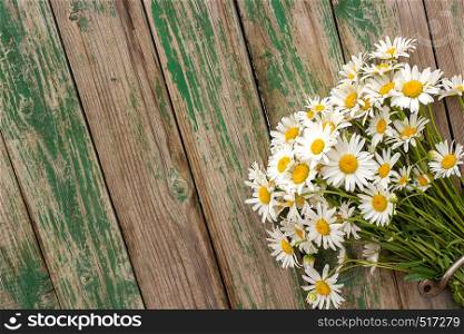 Bouquet field chamomile daisies flowers in door handle on old wooden background. Concept rustic romantic surprise gift. Copy space Minimal style, template for lettering text or your design. Greeting card.. Bouquet field chamomile daisies flowers in door handle on old wooden background. Concept rustic romantic surprise. Copy space Minimal style, template for lettering text or your design. Greeting card