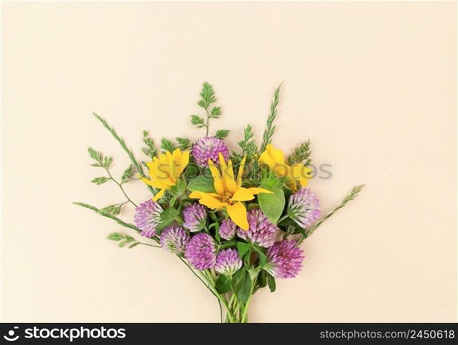 Bouquet from variety of wildflowers on a beige background.. Bouquet from variety of wildflowers on beige background.