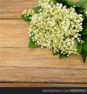 Bouquet lily of the valley on wooden table. Spring flowers on old wooden background. Top view.