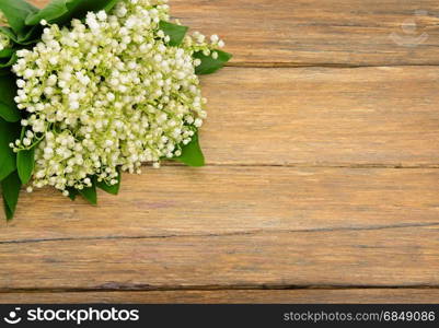 Bouquet lily of the valley on wooden table. Spring flowers on old wooden background. Top view. Copy Space for your text.