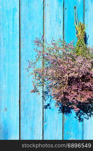 bouquet Limonium hanging on a wooden blue wall, empty space on the left