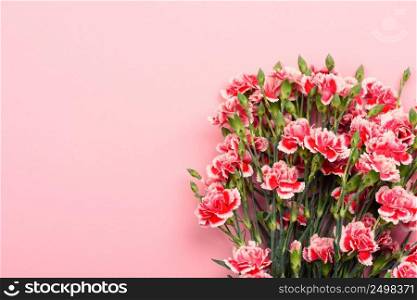 Bouquet of beautiful red and white carnation flowers on pastel pink background. Top view with copy space.