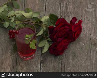 bouquet of beautiful roses and glass of juice of red color, festive card on a subject flowers