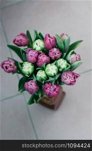 bouquet of beautiful tulip flowers in vase on the floor