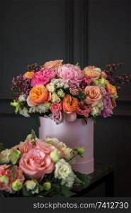 Bouquet of different beauty flowers in round present box on dark background. Bouquet of different beauty flowers
