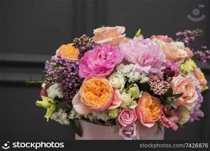 Bouquet of different beauty flowers in round present box on dark background. Bouquet of different beauty flowers