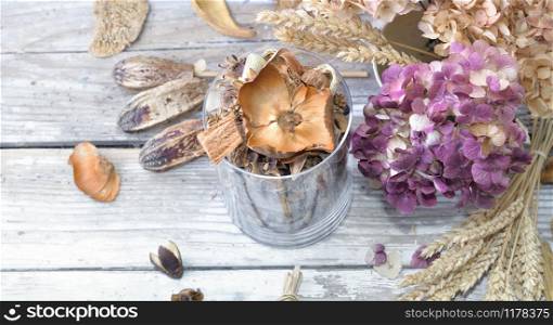 bouquet of dry flowers and potpourri in a glass jar on a white table. bouquet of dry flowers and potpourri on a white table
