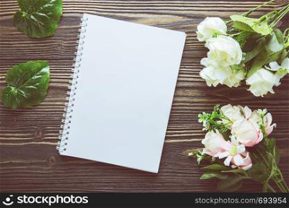 Bouquet of flower and empty diary notebook on rustic wooden table with copy space, mockup template with flower and note, top view, vintage retro style.
