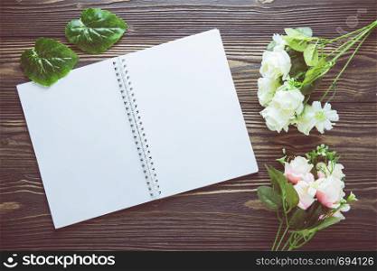 Bouquet of flower and empty diary notebook on rustic wooden table with copy space, mockup template with flower and note, top view, vintage retro style.
