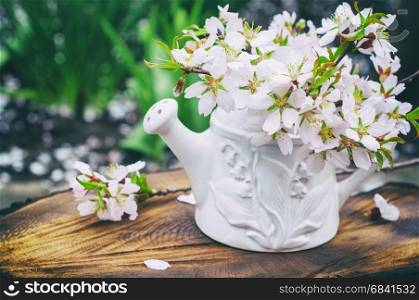 bouquet of flowering almonds in a white vase on hemp, vintage toning