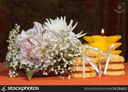 Bouquet of flowers and cookies on an orange background