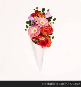 Bouquet of flowers in paper cone on a white background, flat lay. Bouquet of flowers in paper cone on a white background