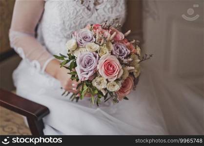 Bouquet of flowers in the hands of the bride in a wedding openwork white dress.. The bride is holding a bouquet of flowers 2287.