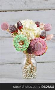 Bouquet of flowers with donuts and macarons