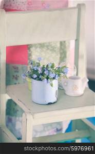 Bouquet of forget-me-not in a blue cup on a wooden windowsill. Forget-me-not in rustic cup
