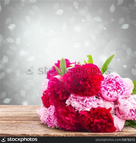 bouquet of fresh pink and red peonies on wooden table . pink and red peonies