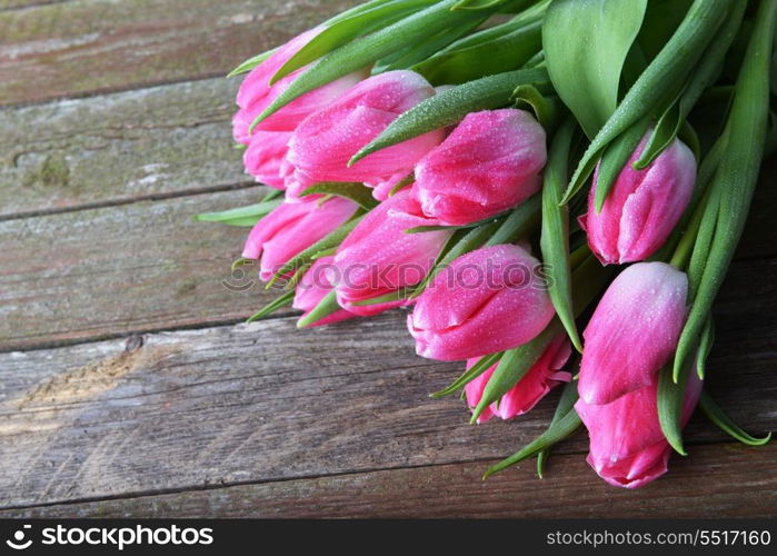 bouquet of fresh pink tulips on wooden background