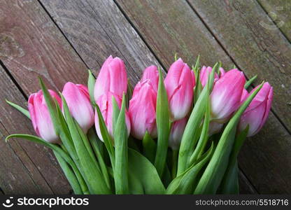 bouquet of fresh pink tulips on wooden background