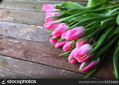 bouquet of fresh pink tulips on wooden background