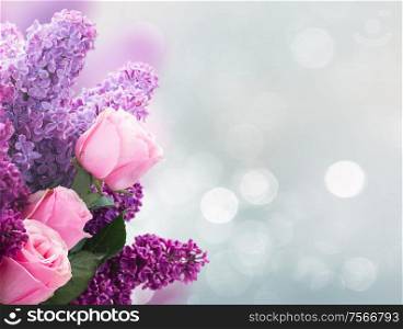 Bouquet of fresh purple Lilac flowers with pink roses over gray background with copy space. Lilac flowers with roses
