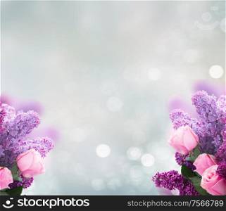 Bouquet of fresh purple Lilac flowers with pink roses over gray bokeh background with copy space. Lilac flowers with roses