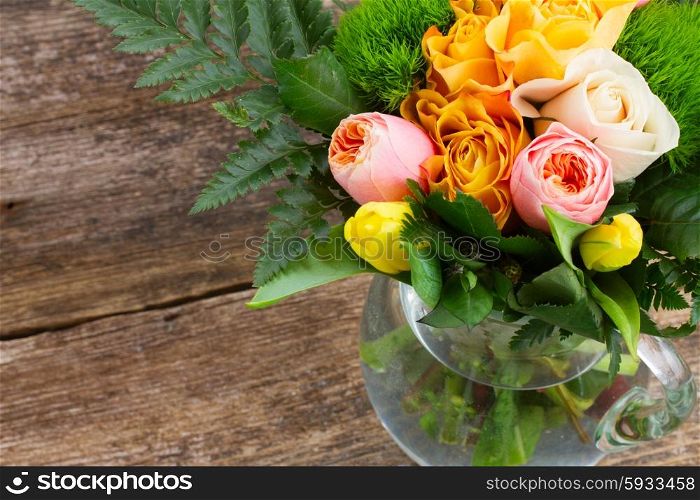 bouquet of fresh spring rose and tulip flowers on wooden background