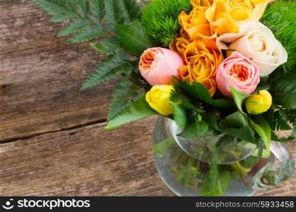 bouquet of fresh spring rose and tulip flowers on wooden background