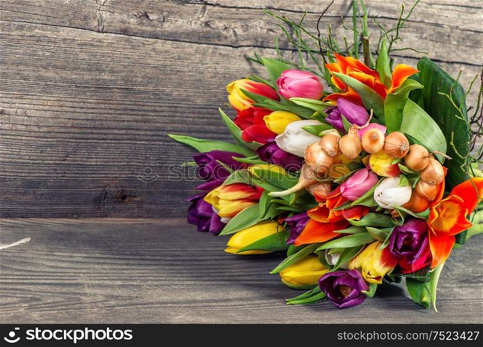 Bouquet of fresh spring tulip flowers on rustic wooden background