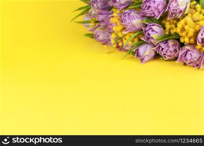 Bouquet of lilac tulips and yellow mimosas on yellow background, copy space, side view, closeup. March 8, February 14, birthday, Valentine?s, Mother?s, Women?s day celebration, spring concept.