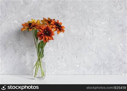 Bouquet of orange flowers coneflowers in vase on table agains gray wall. Copy space Minimal style. Template for postcard, text, design Concept Women's day, Mothers Day, Hello summer, Hello autumn.. Bouquet of orange flowers coneflowers in vase on table agains gray wall. Copy space Minimal style. Template for postcard, text, design Concept Women's day, Mothers Day, Hello summer, Hello autumn