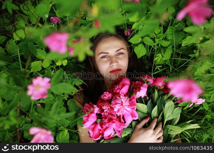 Bouquet of Peony. Stylish fashion photo of beautiful young woman lies among peonies. Holidays and Events. Valentine?s Day. Spring blossom. Summer season. Bouquet of Peony. beautiful young woman lies among peonies. Holidays and Events. Valentine?s Day. Spring blossom.