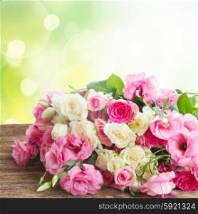 bouquet of pink and white fresh roses and eustoma flowers on garden bokeh background. bouquet of fresh roses