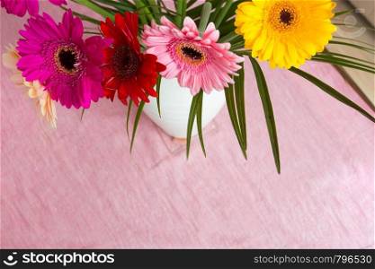 Bouquet of pink daisies in white vase on pink background, colorful flowers view above beauty. Bouquet of pink daisies in white vase on pink background, colorful flowers view above