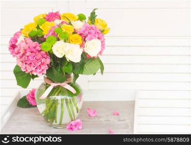bouquet of pink hortensia , yellow and white fresh roses in vase