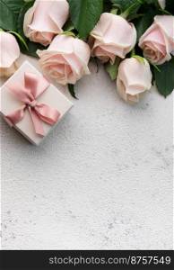 Bouquet of pink roses and gift box  on a concrete background. Valentine’s Day