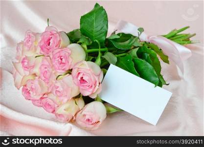 Bouquet of pink roses on satin fabric background