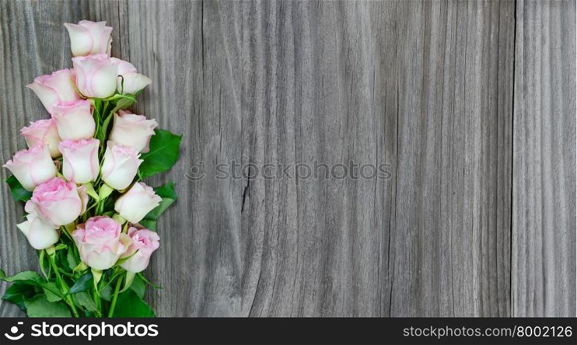 Bouquet of pink roses on the background of the old gray wooden boards