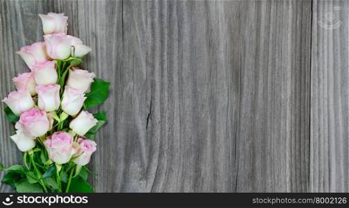 Bouquet of pink roses on the background of the old gray wooden boards