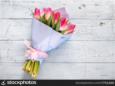 Bouquet of pink tulips on the wooden background