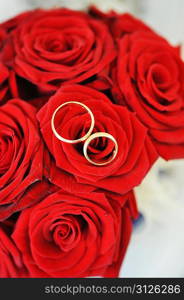 bouquet of red roses and wedding gold rings