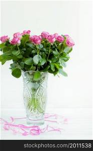 bouquet of roses in a crystal vase on a white background. a bouquet of roses in a crystal vase