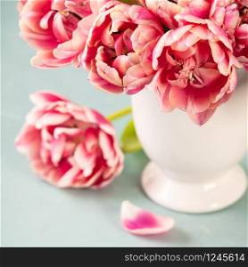 Bouquet of Spring tulips in vase on shabby chic background, day light