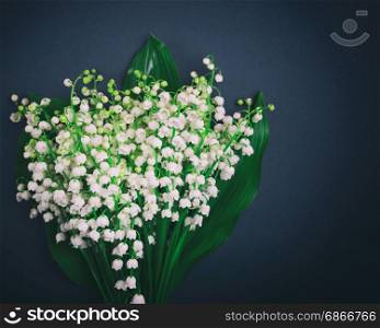 Bouquet of white blossoming lilies of the valley on a black background