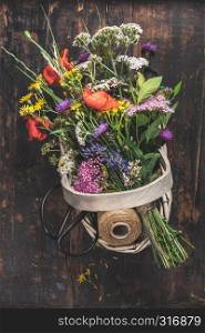 Bouquet of wild flowers in a basket. Flat lay, top view