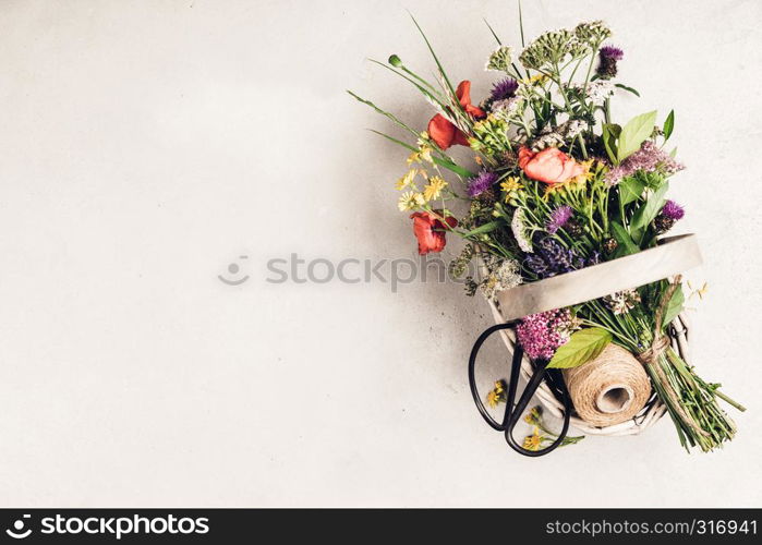 Bouquet of wild flowers in a basket. Flat lay, top view