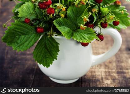 bouquet of wild strawberry on wooden background
