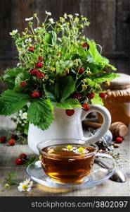 bouquet of wild strawberry with herbal tea and honey - bio food or health concept
