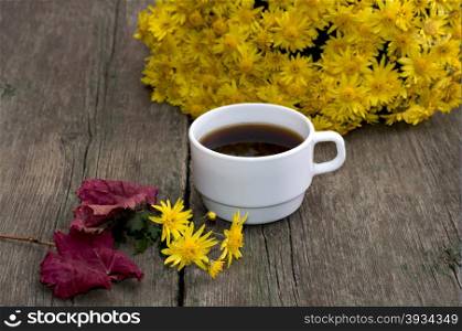 bouquet of yellow flowers, coffee, red leaf and floret, on a wooden table, fall a still life, a subject flowers and drinks