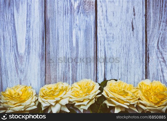 Bouquet of yellow roses on a white wooden background, vintage toning