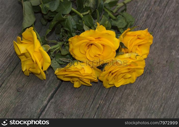 bouquet of yellow roses on a wooden table